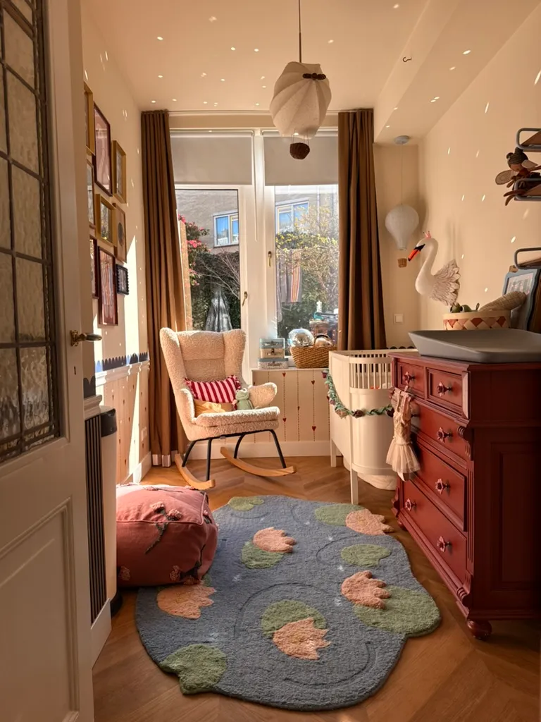 The Swan’s Nursery, a sheepskin rocker, a felt swan on the wall and a berry red dresser in golden light